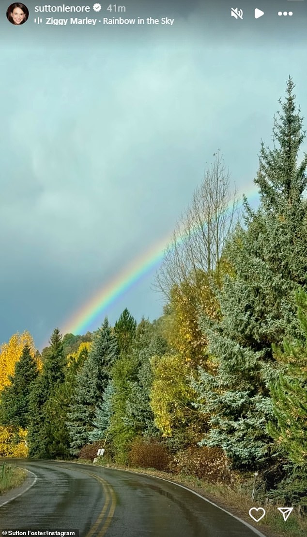 Foster shared a photo of a rainbow soaring over a road winding through the woods