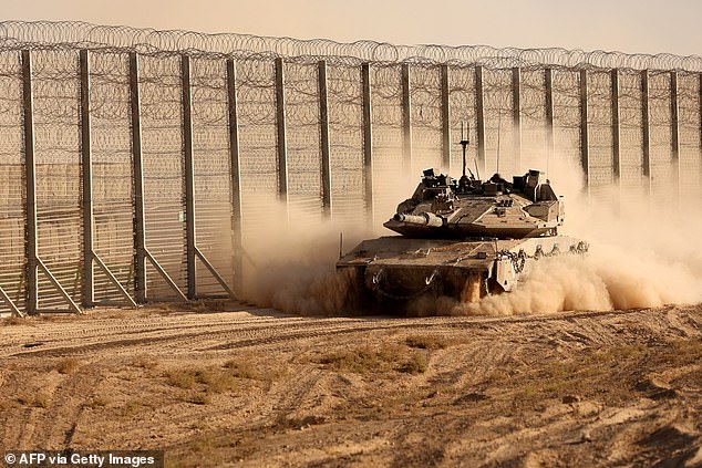 An Israeli tank moves along the border fence between Israel and the Gaza Strip on Tuesday
