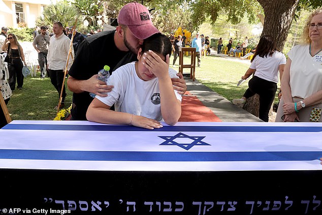 Yuval and Tom, the daughter and the brother of Ronen Engel, an Israeli man abducted from his home and murdered by Hamas in the October 7 attacks, mourn over his coffin during his funeral at the southern Israeli kibbutz of Nir Oz, on Tuesday