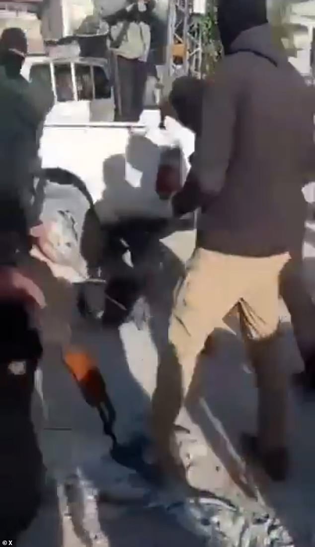 One masked man can be seen stepping on the body of another man who had just been beaten on the ground in Gaza