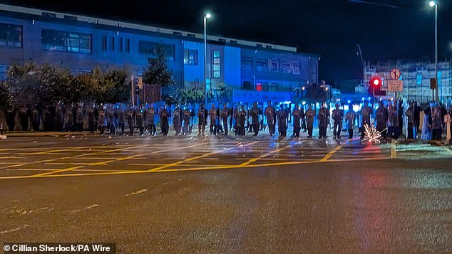 Protesters are seen throwing fireworks at gardai officers by the hotel