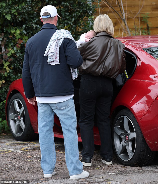 An exhausted Katherine cradled the sleeping Holland in her arms as the couple climbed from their car