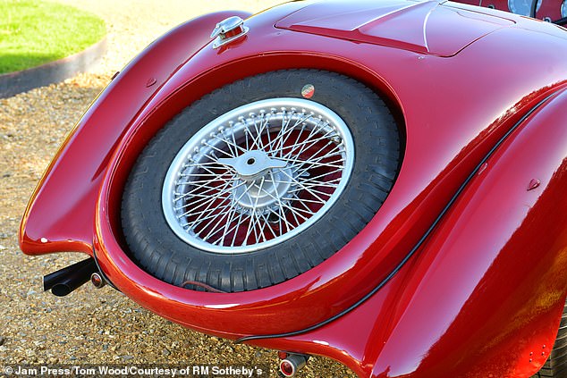The car's spare tire is fitted tucked neatly into the rear of the vehicle
