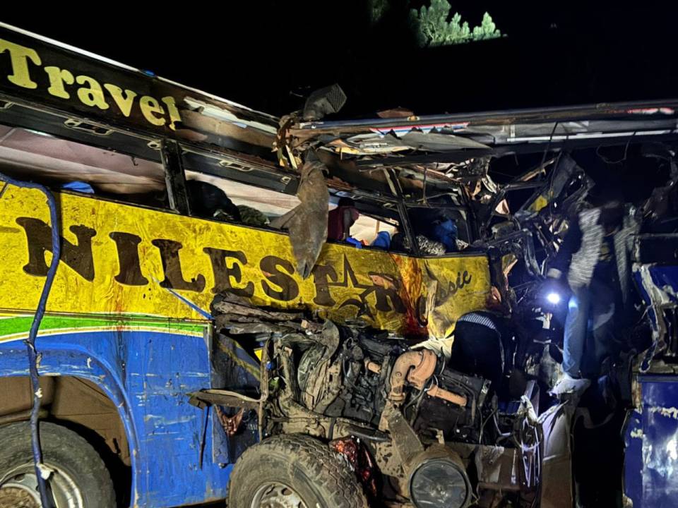 Wreckage of a blue and yellow bus at night.