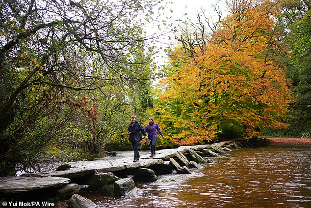 People walking on the Tarr Steps across the River Barle at Exmoor National Park yesterday