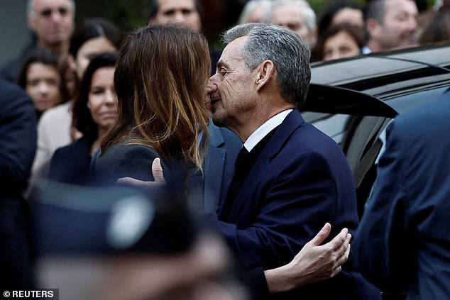 Former French President Nicolas Sarkozy kisses his wife Carla Bruni-Sarkozy before leaving in a car on the day of his incarceration at the La Sante prison