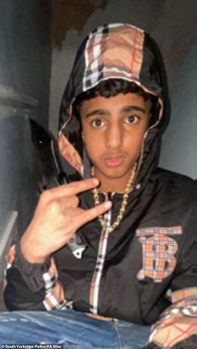 Khan is pictured holding the weapon used to kill fellow pupil Harvey, who he stabbed to death