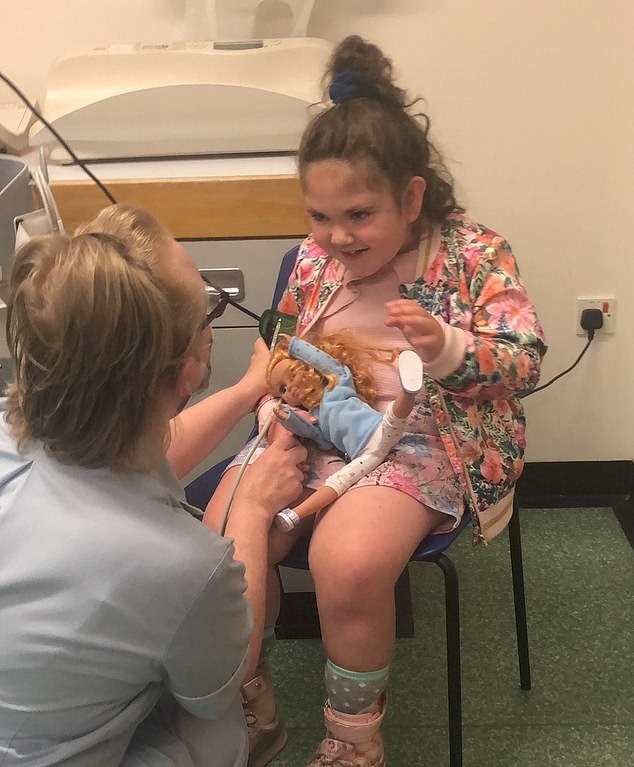 Orla (pictured in hospital) began struggling to walk up stairs around four years ago