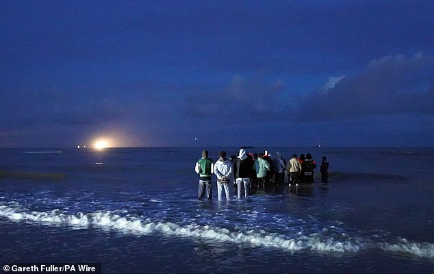 Migrants waiting on the French coast to be picked up by a so-called 'taxi boat' yesterday