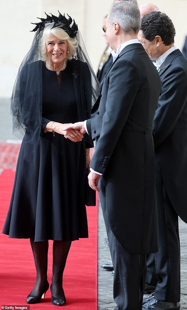 Queen Camilla is welcomed by officials at San Damaso Courtyard at Vatican City today