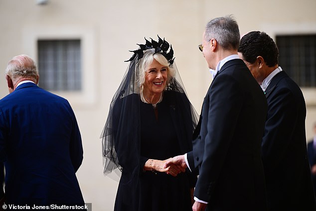 Queen Camilla is welcomed by officials at San Damaso Courtyard at Vatican City today