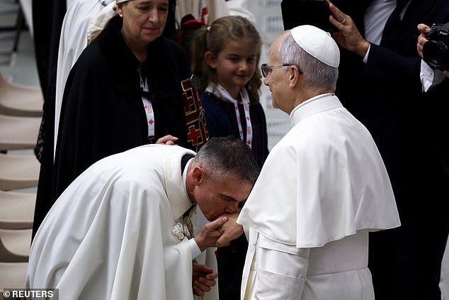 A man kisses the hand of Pope Leo XIV during a meeting at the Vatican this morning