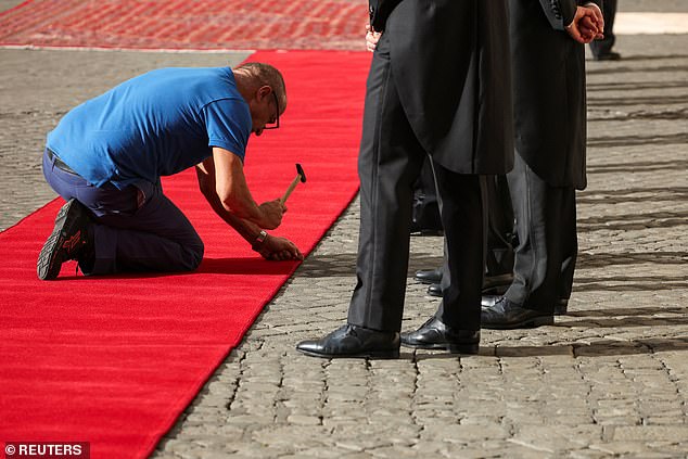 Workers set up a red carpet at Vatican City today ahead of the arrival of the King and Queen