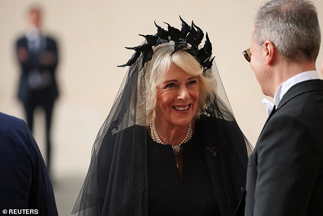 Queen Camilla is welcomed by officials at San Damaso Courtyard at Vatican City today