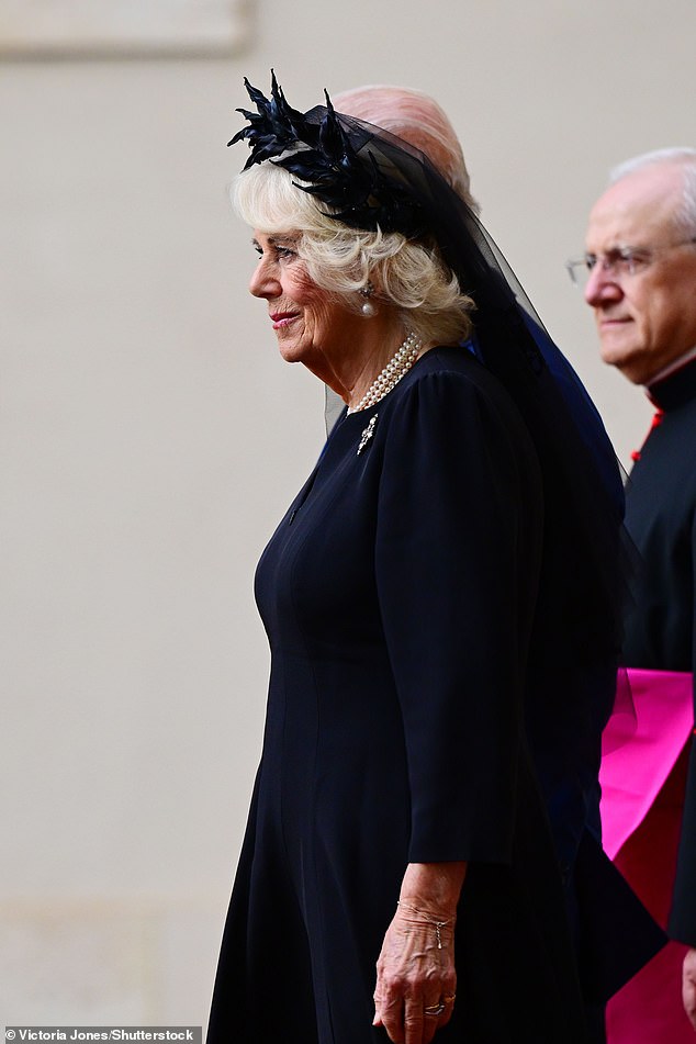 Queen Camilla is welcomed by officials at San Damaso Courtyard at Vatican City today