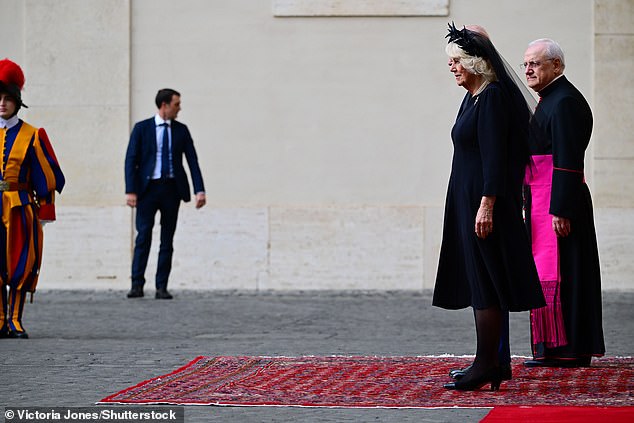 Queen Camilla is welcomed by officials at San Damaso Courtyard at Vatican City today