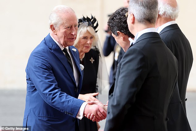 King Charles III and Queen Camilla are welcomed by officials at San Damaso Courtyard today