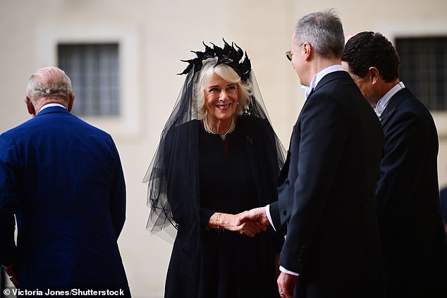 Queen Camilla is welcomed by officials at San Damaso Courtyard at Vatican City today
