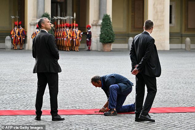 Workers set up a red carpet at Vatican City today ahead of the arrival of the King and Queen