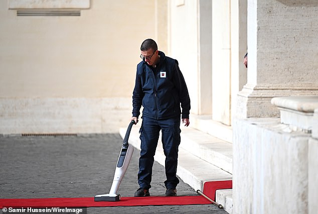Workers set up a red carpet at Vatican City today ahead of the arrival of the King and Queen