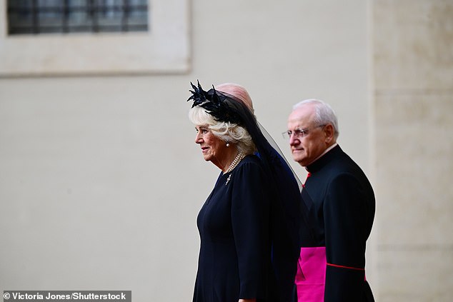 Queen Camilla is welcomed by officials at San Damaso Courtyard at Vatican City today