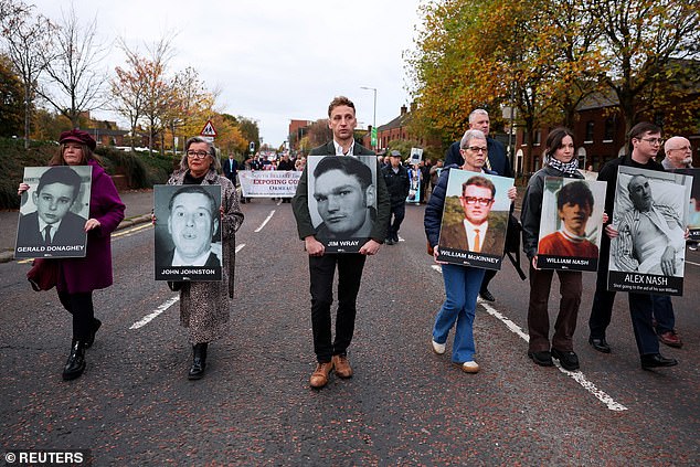 Bereaved family members hold pictures of victims of Bloody Sunday' before the judge's verdict