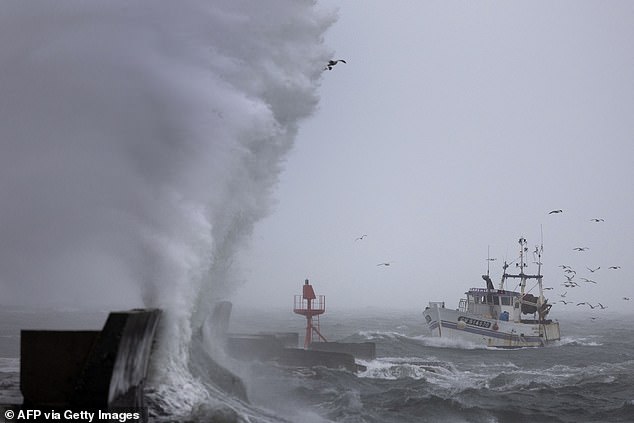 A fishing boat arrives at the port in Plobannalec-Lesconil, western France, October 22, 2025, as huge waves and strong winds hit the coast at the passage of the storm Benjamin