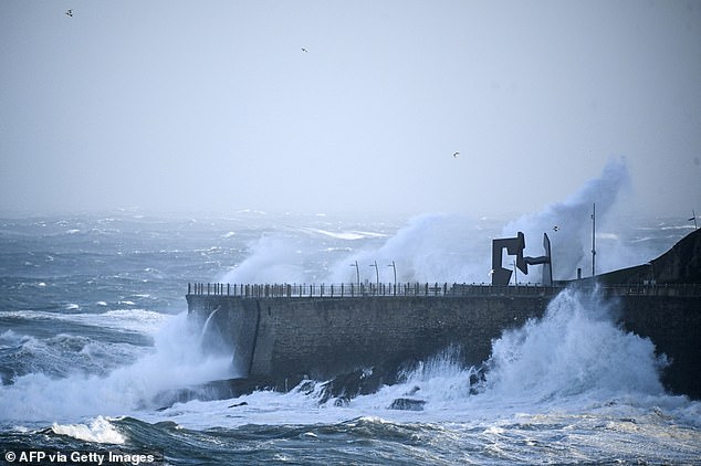 Big waves hit a seaside promenade where Spanish artist Jorge Oteiza's sculpture 'Construccion Vacia' (Empty Construction) is located during a weather alert for rough seas and strong winds in the northern Spanish Basque city of San Sebastian on October 23, 2025