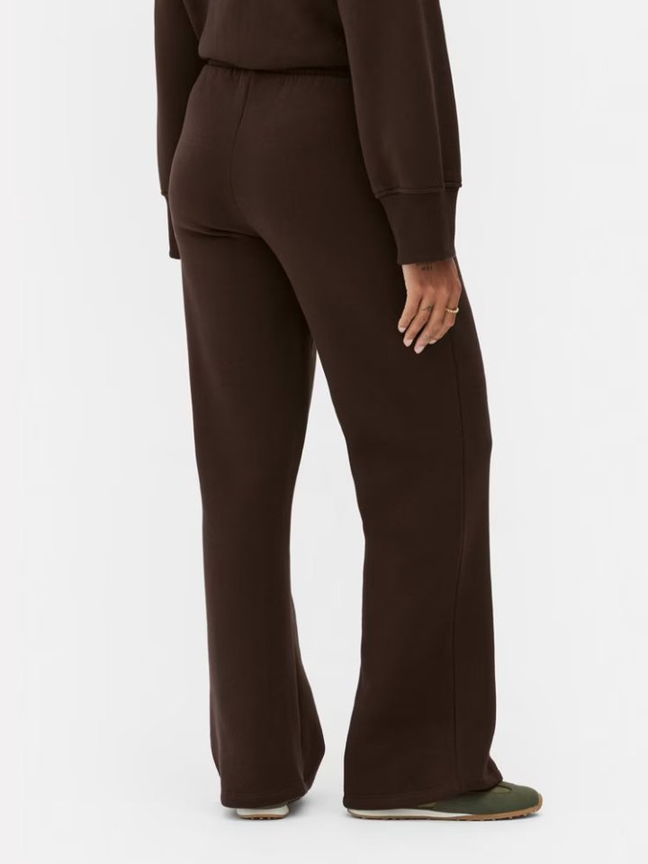 Back view of person wearing brown joggers and sneakers.