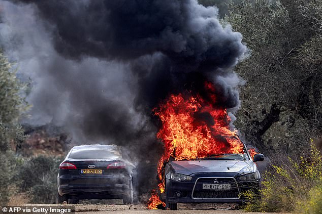 The vehicle of AFP's photographer Jaafar Ashtiyeh is pictured ablaze after it was set on fire during an attack by Israeli settlers on the Palestinian village of Beita, south of Nablus in the occupied West Bank, on October 10, 2025 during the annual olive harvest season