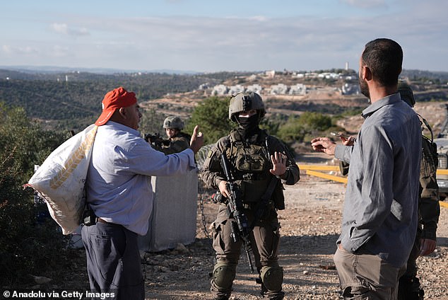 Israeli soldiers and Palestinian farmers attempting to reach their fields for the olive harvest in the village of Kuber, near Ramallah, West Bank on October 18, 2025