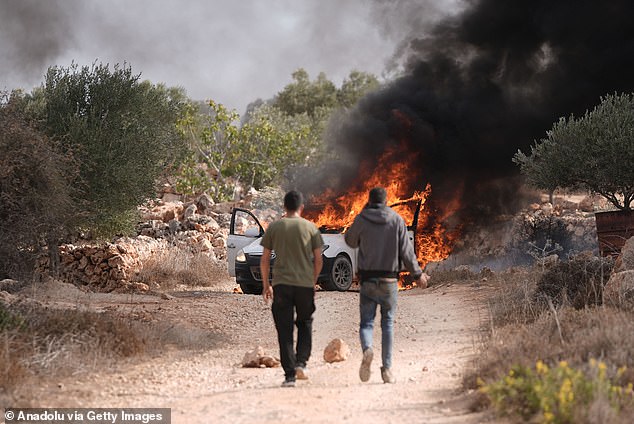 Smoke and flames rise from vehicles belonging to Palestinians in the village of Turmus Ayya near Ramallah, West Bank, on October 19, 2025