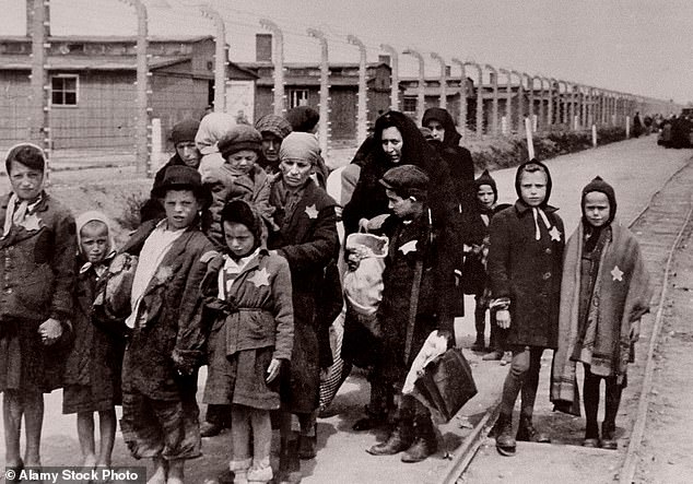 Jewish children wearing Nazi-designated yellow stars are pictured arriving in Auschwitz-Birkenau