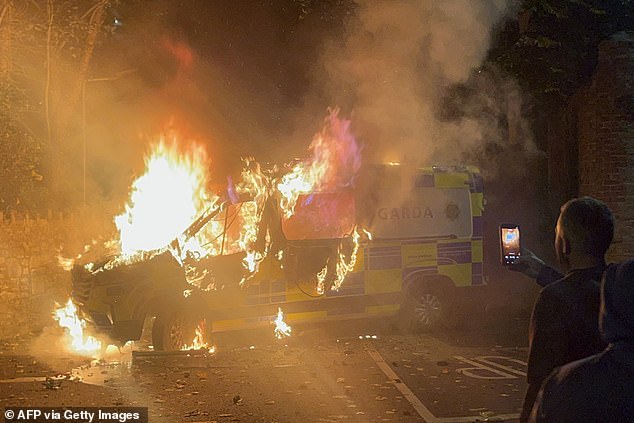 A police vehicle (pictured) was burned as a demonstration outside the hotel turned violent on October 21
