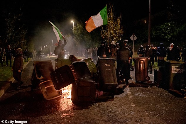 Masked rioters set fire to bins (pictured) near the hotel on October 21 as mayhem gripped the streets of Dublin