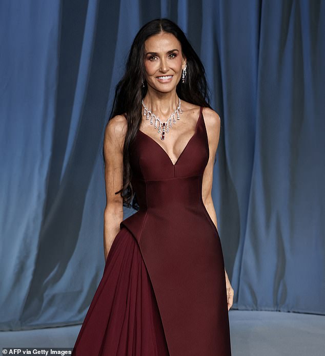 Demi Moore wears a burgundy dress and shows off her waist-length curls at the Academy Museum Gala in Los Angeles on October 18