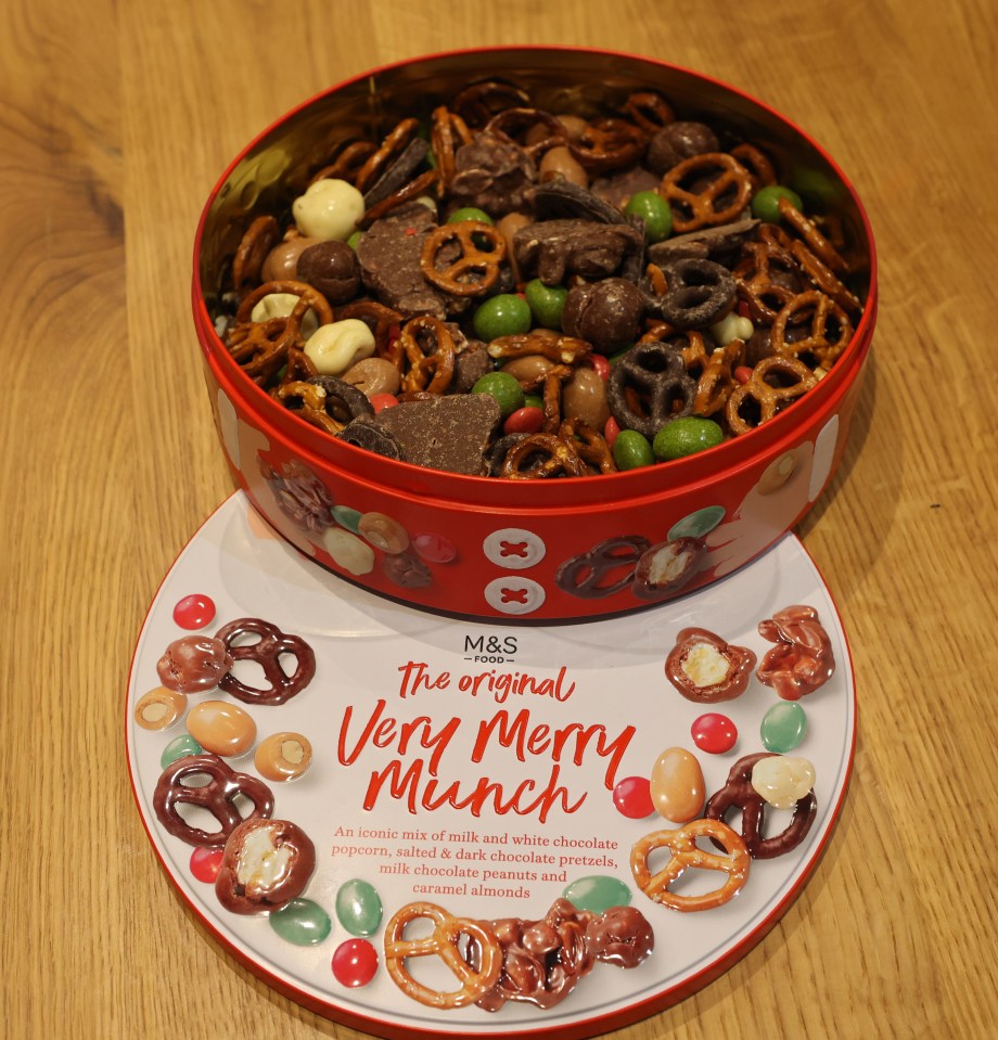 M&S's Very Merry Munch tin filled with chocolate, pretzels, and candies.
