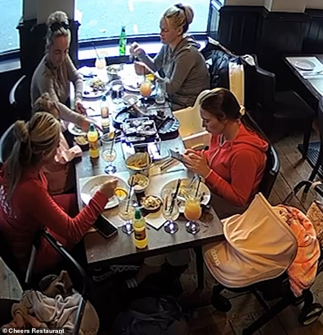 CCTV shows the women enjoying a hearty meal as they down their drinks with their young children sat beside them