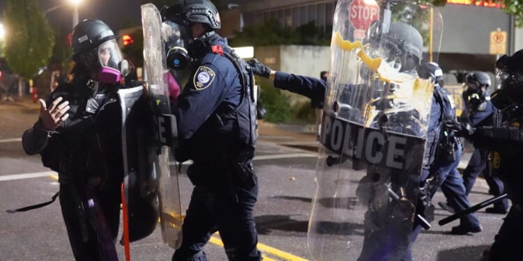 A rioter clashes with federal officers at an Immigration and Customs Enforcement detention facility in Portland, Oregon, on Aug. 20, 2020.