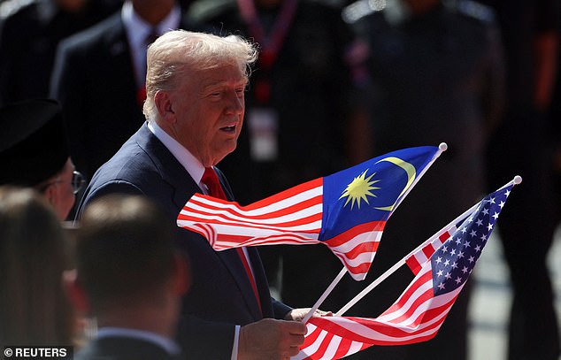 Trump grabbed an American and a Malaysian flag before posing for photos with the eager crowd