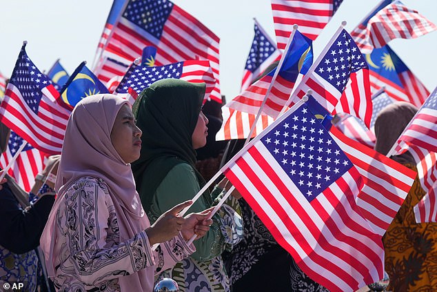 A crowd holding American and Malaysian flags applauded Trump as he danced