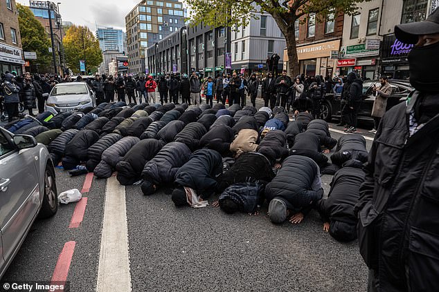 Members of the Bangladeshi community praying during a counter demonstration outside an east London Mosque