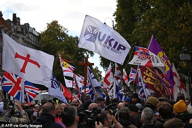 Supporters of UK Independence Party (UKIP) wave flags during a march in London on October 25