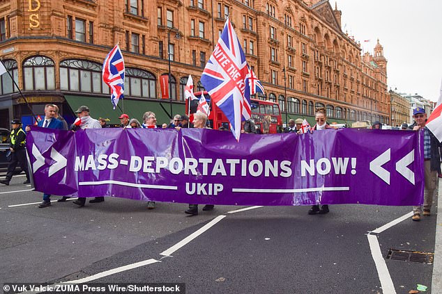 Protesters pass by Harrods with a banner during a march organised by UKIP