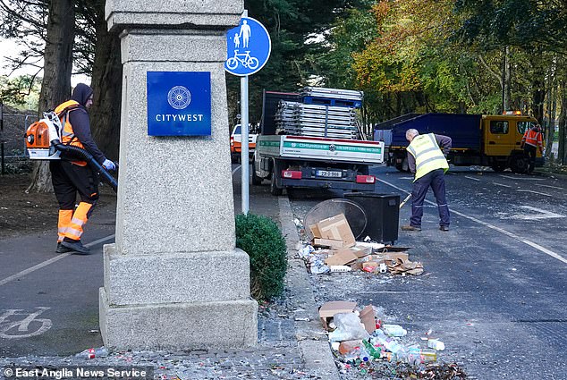 Workers are seen cleaning the roads or hoovering debris left behind by demonstrators