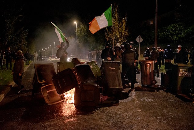 Masked rioters set fire to bins (pictured) near the hotel on October 21 as mayhem gripped the streets of Dublin