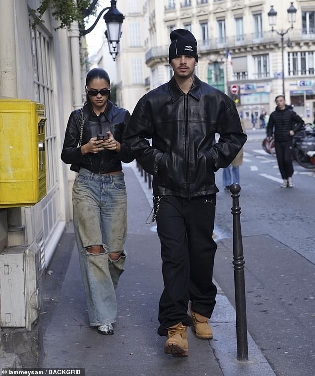 Meanwhile Kim opted for a cropped leather jacket with blue ripped jeans, white boots and a pair of sunglasses