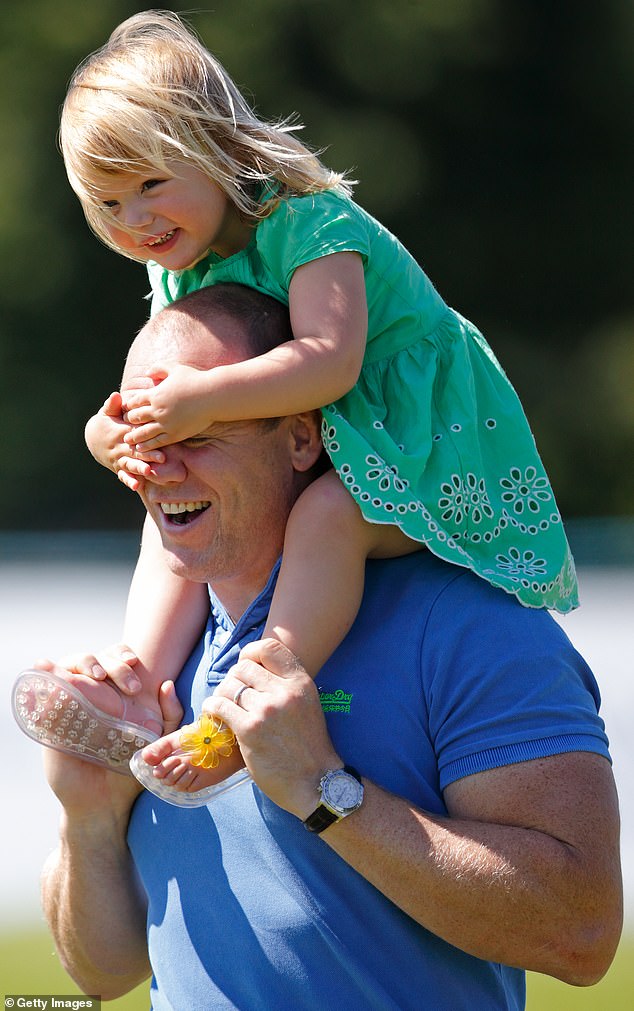 Later that year, when feeling more awake, Mia covered her father's eyes and smiled (pictured) while he carried her on his shoulders at the Festival of British Eventing