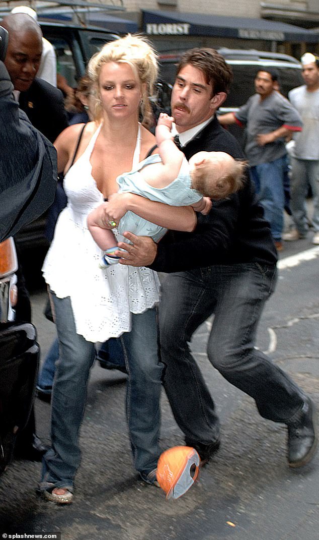 Federline says the hot-tempered Spears (pictured almost dropping her baby Sean Preston in 2006) punched one of her children in the face and threatened him with a knife