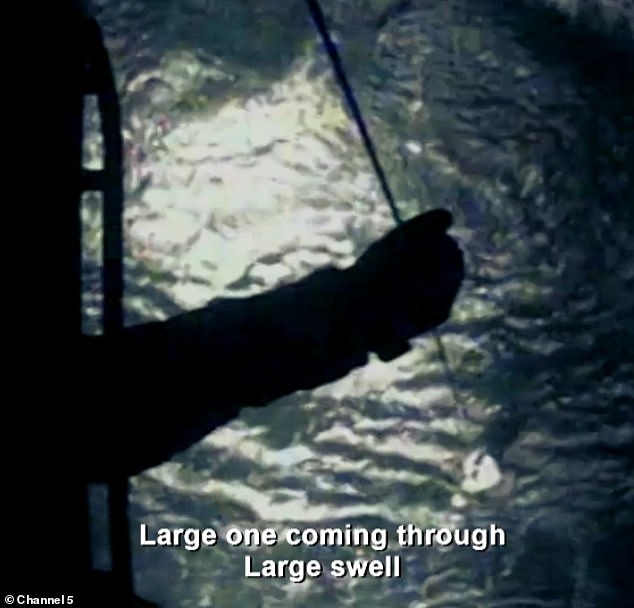 A winchwoman from the coastguard team is lowered towards the water to try to save the man